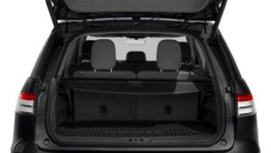 A trunk of a car with the back seats open.