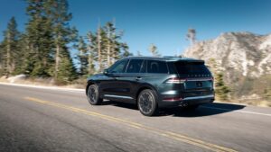 A green lincoln aviator driving down the road.