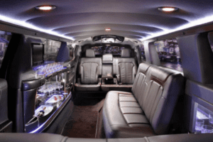 A limo car with leather seats and drinks on the back.