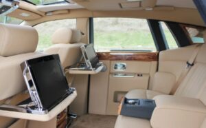 A car with the back seats open and a laptop on the desk.