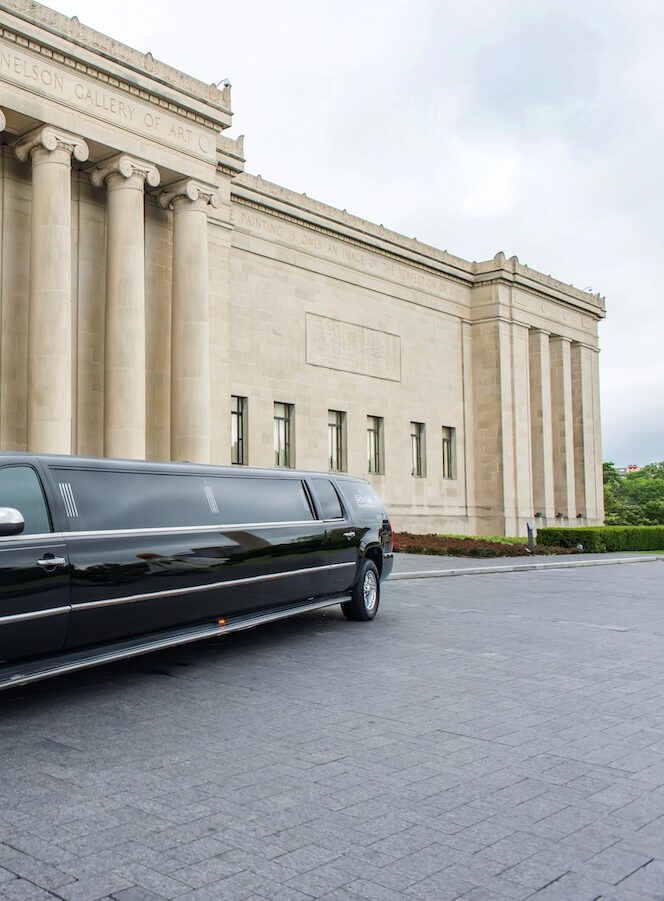 A black limo is parked in front of a building.