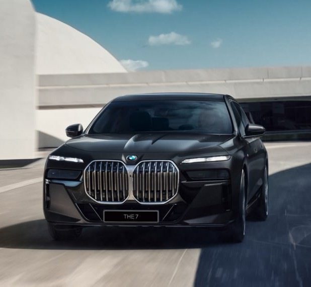 A black bmw car driving down the road.