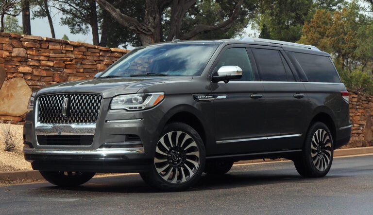 A gray lincoln navigator parked on the side of a road.