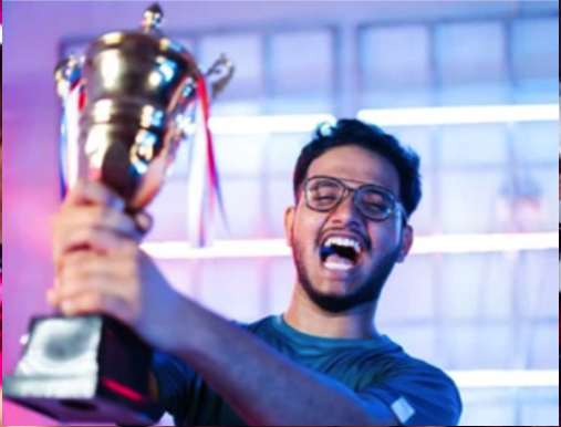 A man holding up a trophy in front of a crowd.