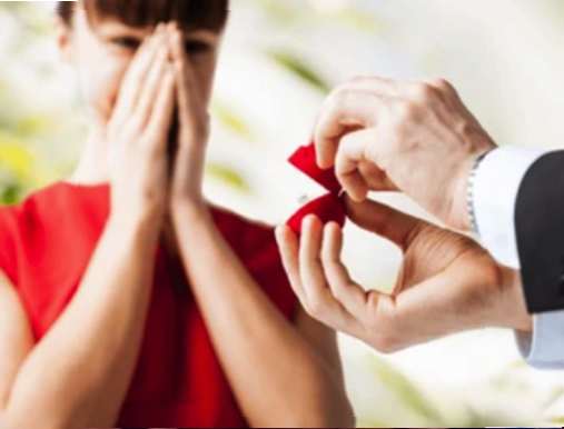 A man is holding out his wedding ring to the woman.