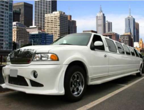 A white limo is parked on the side of the road.