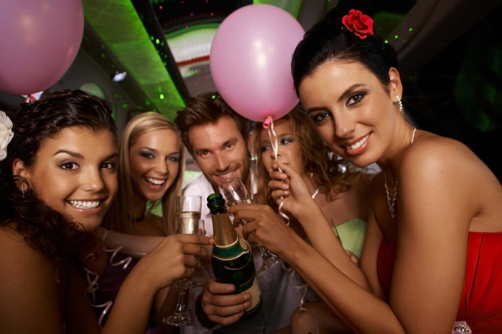 A group of people holding champagne and balloons