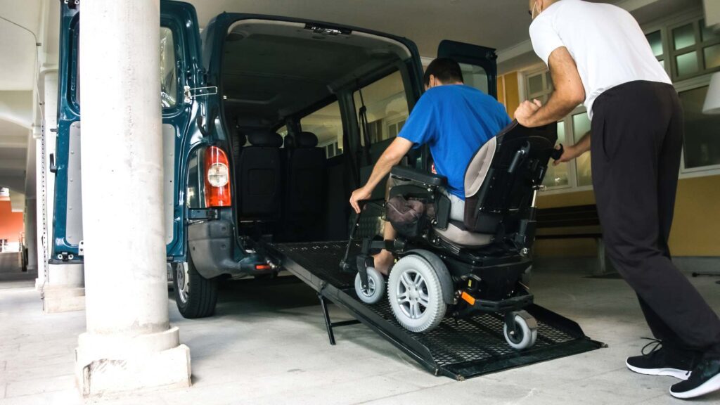 A man in a wheelchair is on the back of a van.