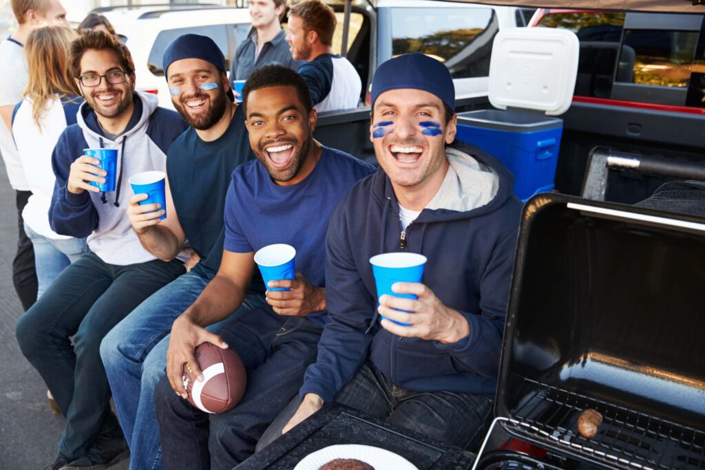 A group of men sitting next to each other holding cups.