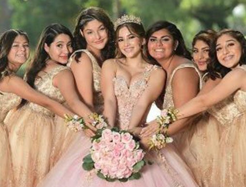 A group of girls in dresses holding flowers.