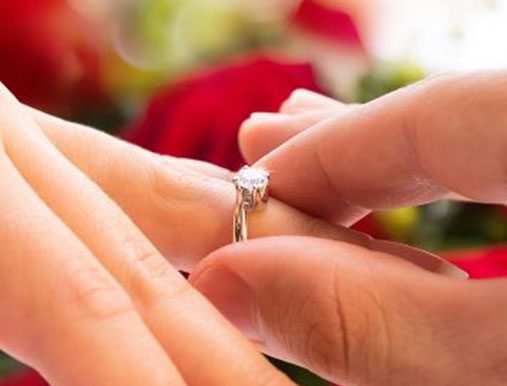 A person is holding onto the ring of their wedding band