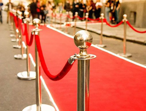 A red carpet with a rope and silver poles.