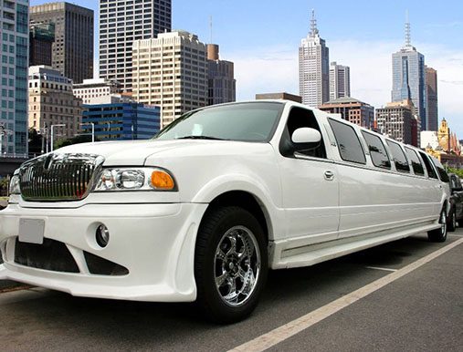 A white limo is parked on the street.