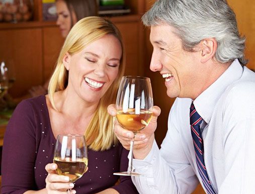 A man and woman holding wine glasses in their hands.