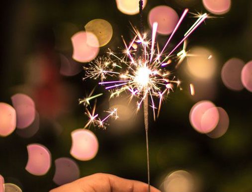 A person holding sparklers in their hand.