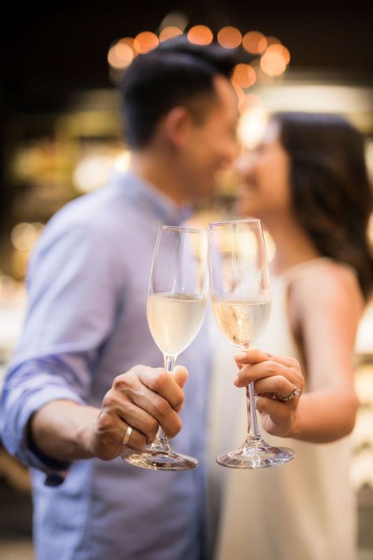 A man and woman holding wine glasses in their hands.