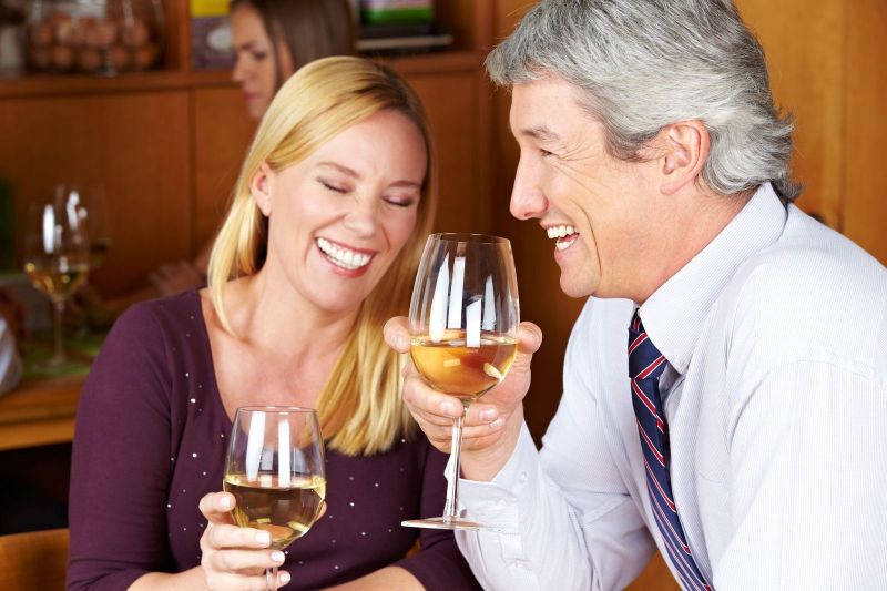 A man and woman holding wine glasses in their hands.