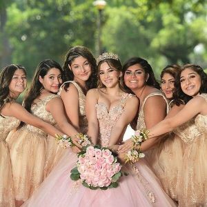 A group of girls in dresses holding flowers.