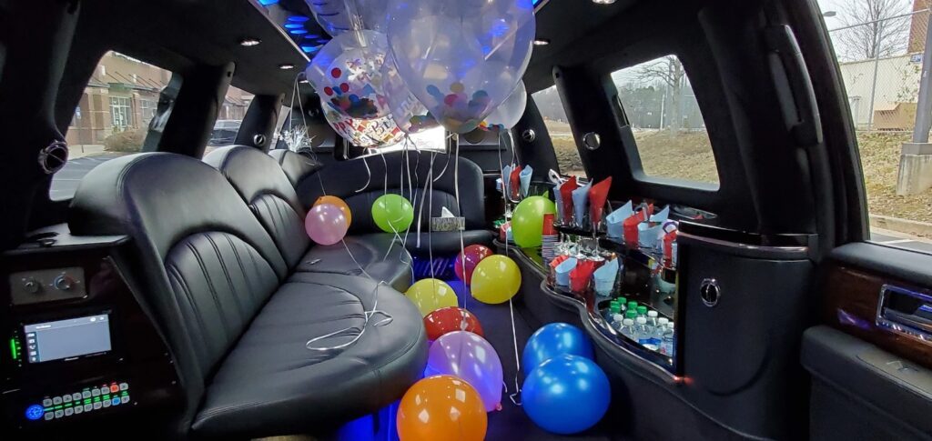 Limousine interior decorated with colorful balloons.