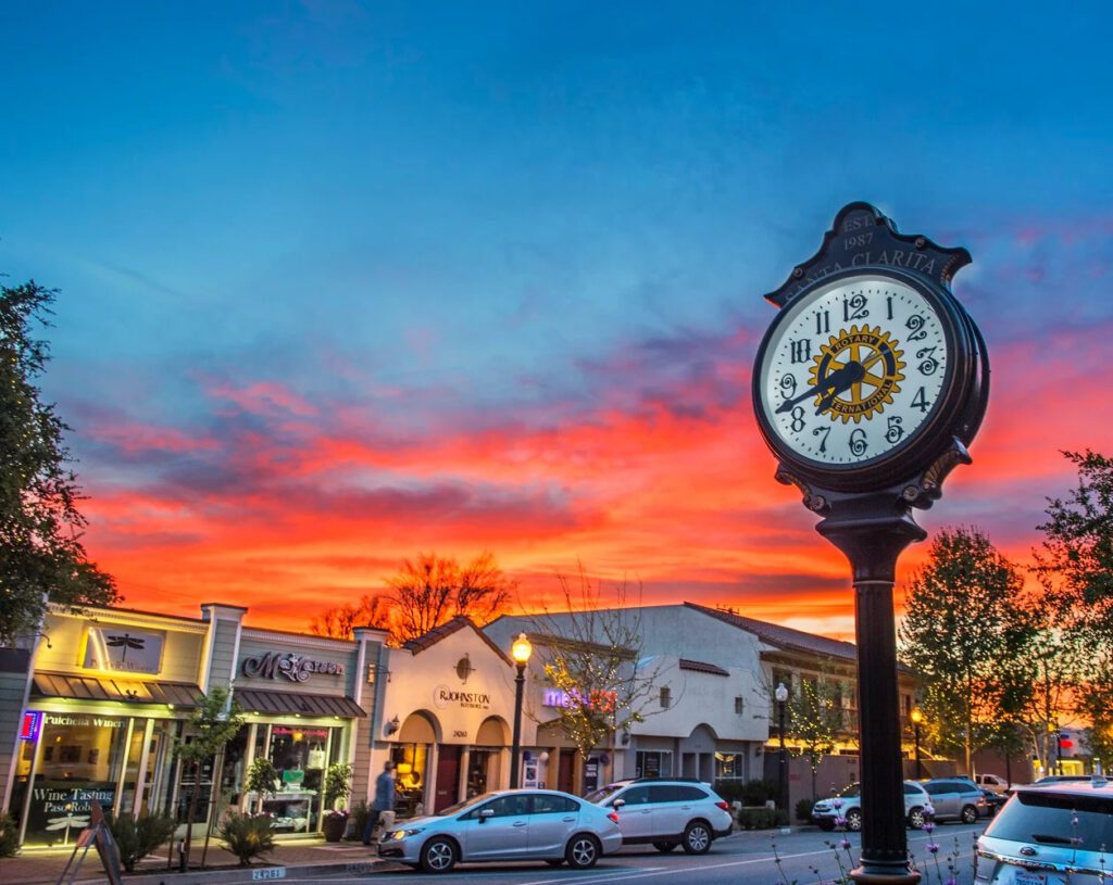 Street clock against vibrant sunset sky.